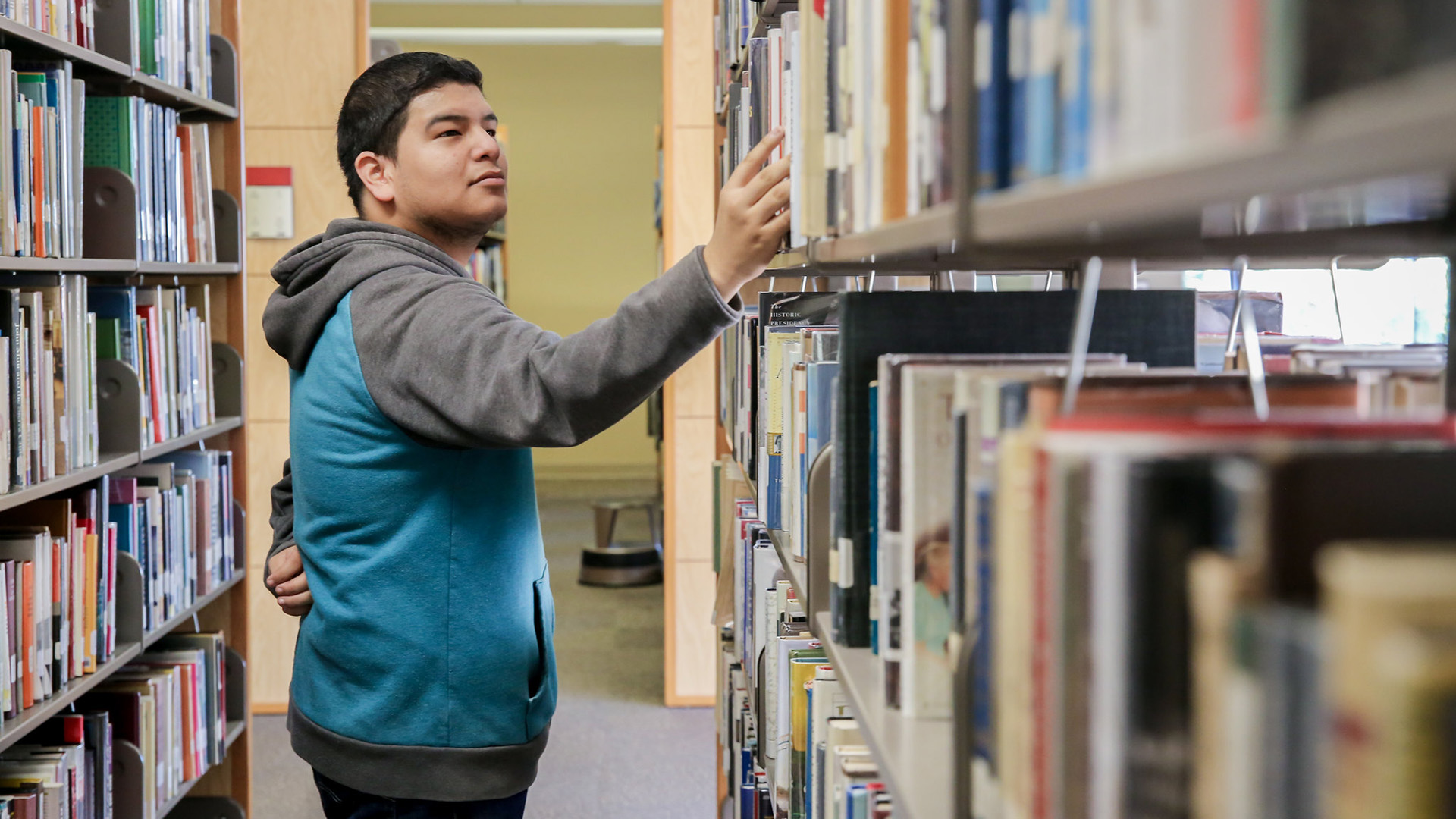 A student looks at books in the campus library